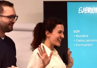 Dos personas haciendo una presentación delante de la pantalla digital
