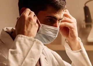 Guillermo Arce poniéndose la mascarilla antes de atender a un paciente