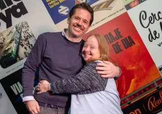 Los dos participantes en el diálogo de RENFE abrazados posando para la foto
