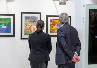 Dos personas observando un cuadro en una exposición