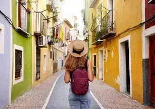Mujer haciendo turismo por una colorida calle (Fuente: Servimedia)