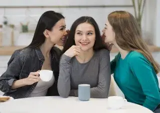 mujeres jovenes hablando al oido a otra mujer sorda