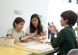 Imagen de Autismo España sobre educación inclusiva en el que aparece una profesora en clase con alumnado con discapacidad