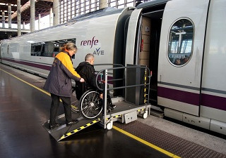 Una persona en silla de ruedas accediendo a un AVE por una rampa con ayuda del personal (Fuente: Servimedia)