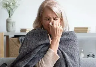 Una persona mayor con síntomas de gripe o resfriado (Fuente: Oticon)