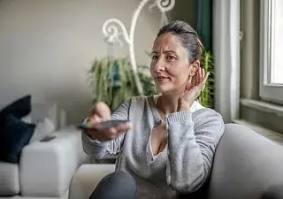 Mujer viendo la tv con audífonos
