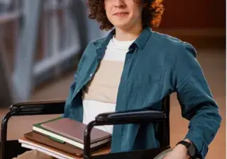 joven en silla de ruedas son unos libros sobre la pierna