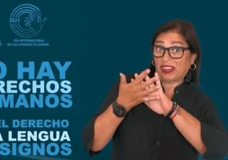 Imagen de una mujer con gafas y camisa negra haciendo un gesto con las manos, sobre un fondo azul con logotipos de la Semana de Personas Sordas 2025 y CNSE. Texto: "NO HAY DERECHOS HUMANOS SIN EL DERECHO A LA LENGUA DE SIGNOS".