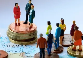 Muñecos subidos a monedas en una representación de la economía social