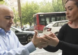 Una mediadora interactúa con un hombre de mediana edad sordociego