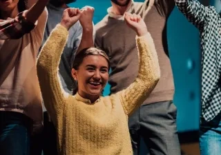 mujer con discapacidad celebrando un logro junto a más personas