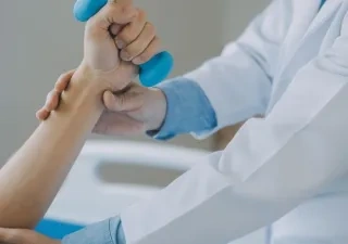 Un sanitario ayuda a un paciente a realizar ejercicios de rehabilitación 