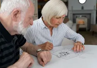 Dos personas mayores realizando un puzzle (Fuente: Servimedia)