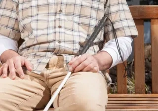 Una persona ciega descansa en un banco