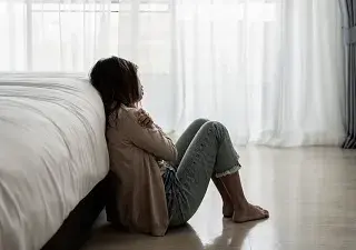 Una mujer con depresión, sentada en el suelo de su casa (Fuente: Servimedia)