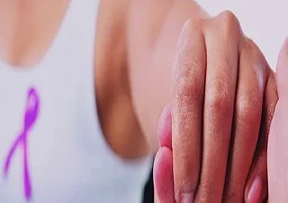 Una mujer con lazo rosa da la mano a otra (Fuente:  (Fuente: Sysmex España)