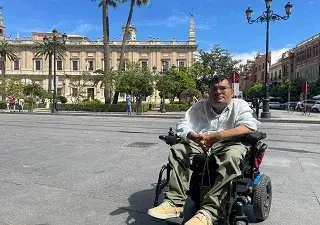 Carlos Reina Rosales, de 35 años y uno de los participantes en este estudio, sentado en su silla de ruedas eléctrica, frente a un museo en el centro de Sevilla (Fuente: Jonas Bull/Human Rights Watch)