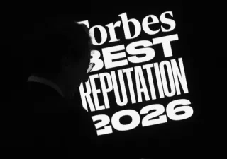 Nombre del evento en blanco sobre fondo negro, se ve también una silueta a la izquierda, del presentador del evento