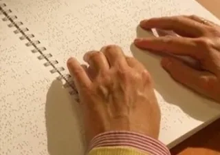 Detalle de una persona leyendo en braille