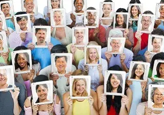 grupos de personas mostrando fotografías de caras sonrientes