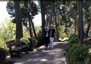 Una persona voluntaria acompaña a otra persona ciega en un paseo (Fuente: ONCE)